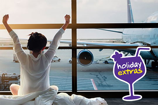 Frau streckt die Arme nach oben, sitzend auf einem Bett mit Blick auf ein Flugzeug am Flughafen